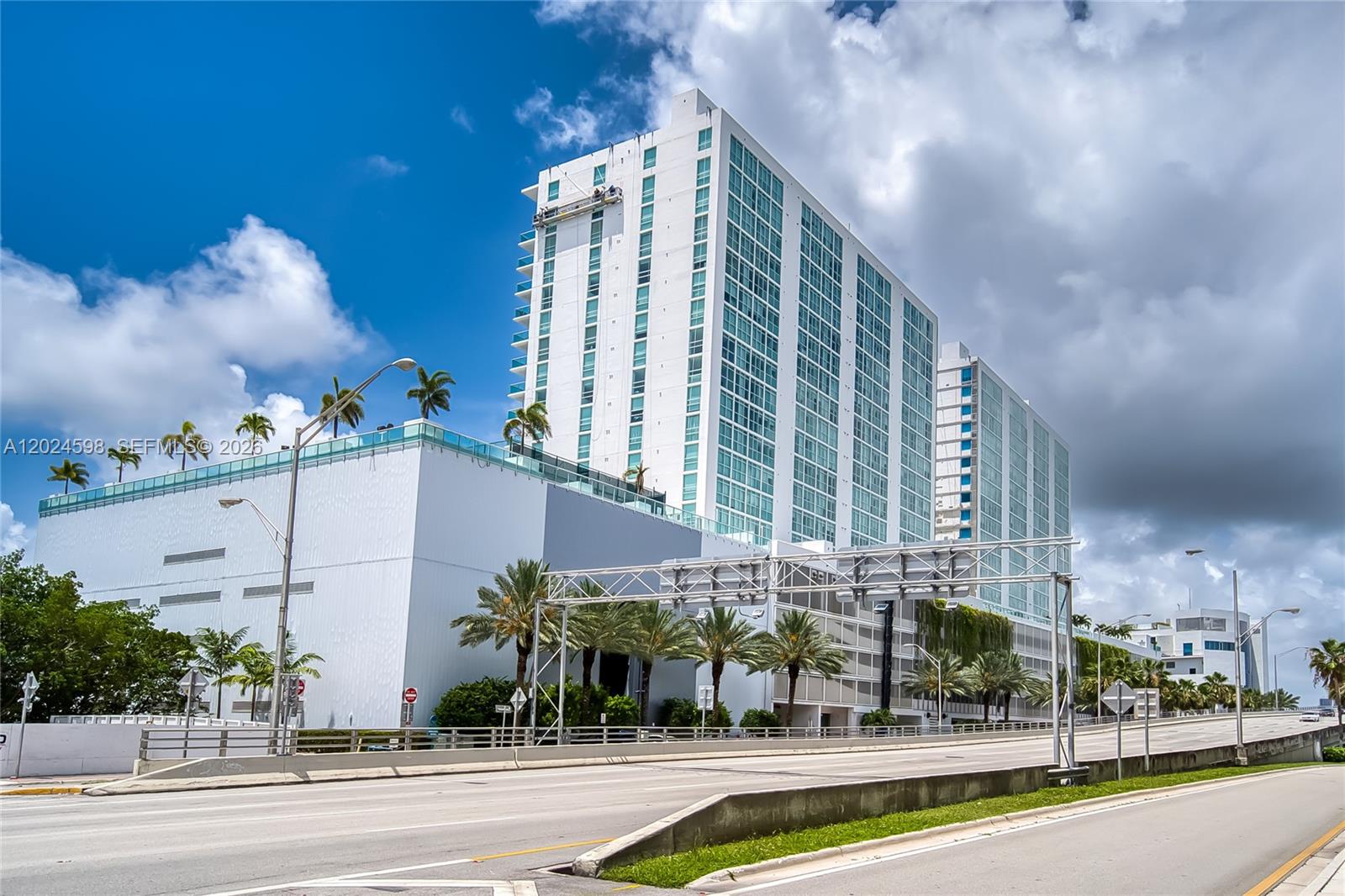 A low-angle exterior view of a modern white high-rise building with a parking garage base — 400 Sunny Isles Blvd # 1202, Sunny Isles Beach FL 33160, SUNNY ISLES BEACH, FL