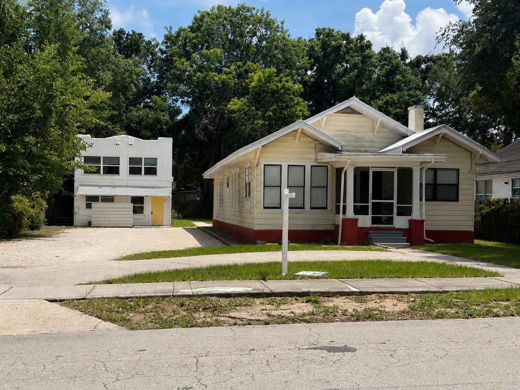 A two-story white house with black shutters and a concrete driveway in front — 514 AVENUE C NE, WINTER HAVEN, FL