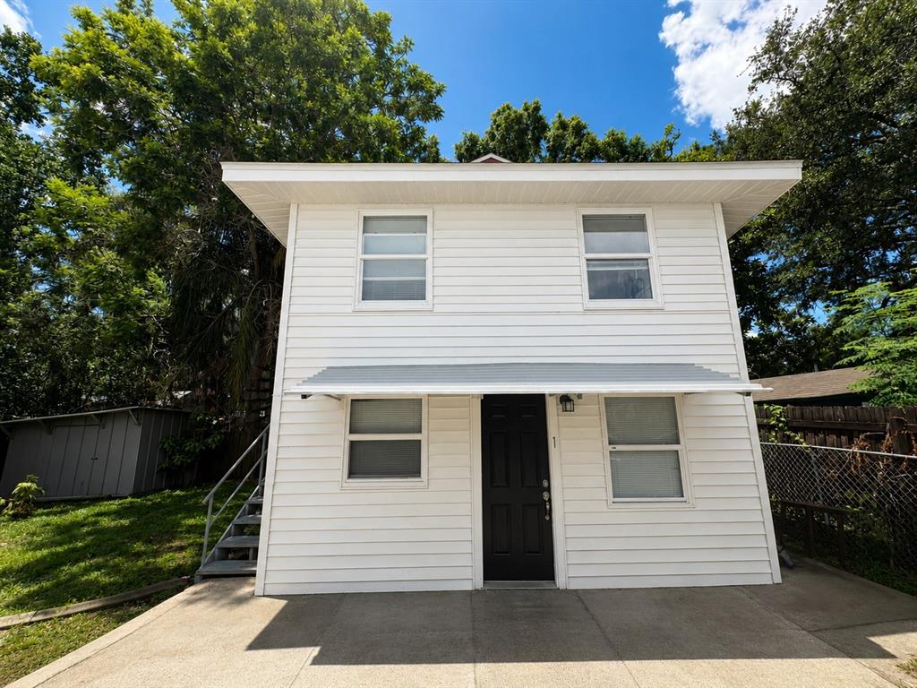 A yellow house with a red foundation stands next to a white two-story detached building — 514 AVENUE C NE, WINTER HAVEN, FL