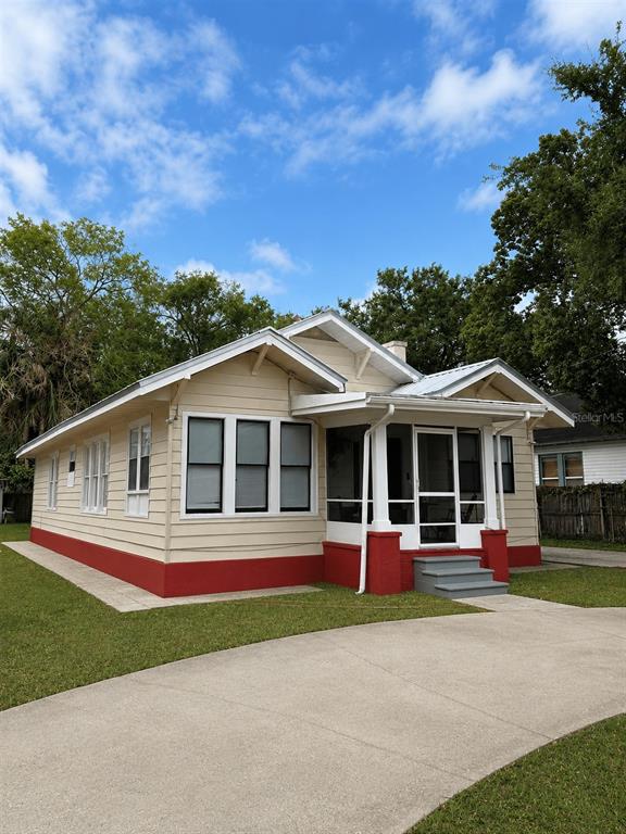 A two-story white stucco building with four windows stands on a concrete foundation — 514 AVENUE C NE, WINTER HAVEN, FL