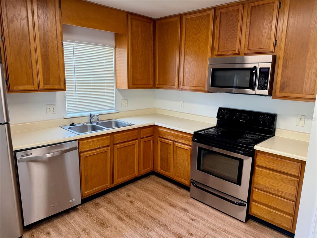 A kitchen with wood cabinets, stainless steel appliances, and light-colored countertops — 4316 CLUBSIDE DRIVE UNIT 4316, LONGWOOD, FL