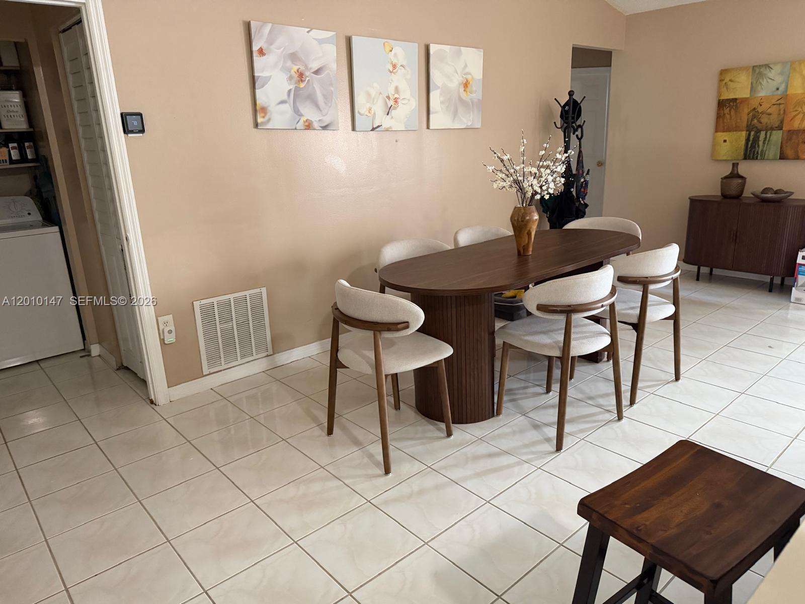 A dining room features a dark wood oval table, six chairs, and tiled flooring — 18109 SW 142nd Ct, Miami FL 33177, MIAMI, FL