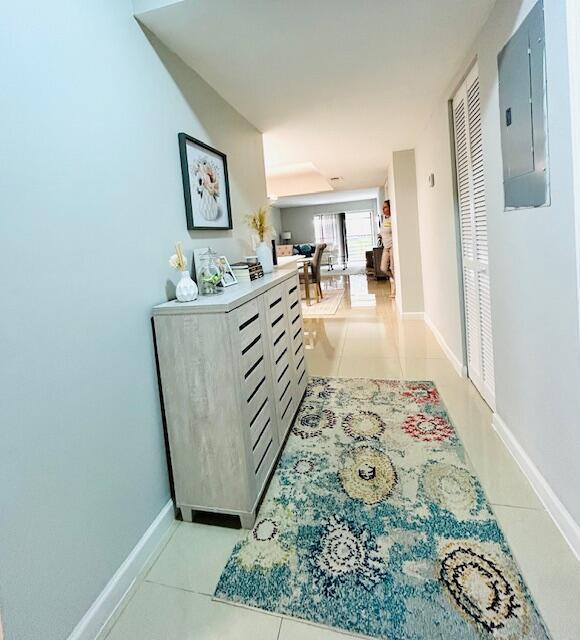 A hallway features a light-colored wooden cabinet, a patterned rug, and a framed floral print — 23370 Carolwood Lane, Boca Raton FL 33428, BOCA RATON, FL