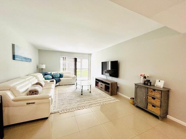 A living room features a white leather sectional, a television on a console, and tile flooring — 23370 Carolwood Lane, Boca Raton FL 33428, BOCA RATON, FL