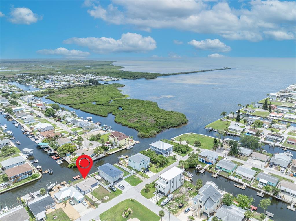 An aerial view shows a waterfront house with a red location pin near a bay — 6416 BOATYARD DRIVE, HUDSON, FL