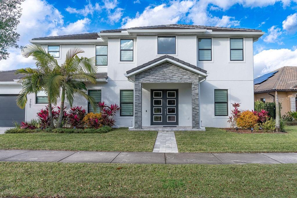 A two-story white house with a stone-accented entryway and a double front door — 7701 SUMMERLAKE POINTE BOULEVARD, WINTER GARDEN, FL
