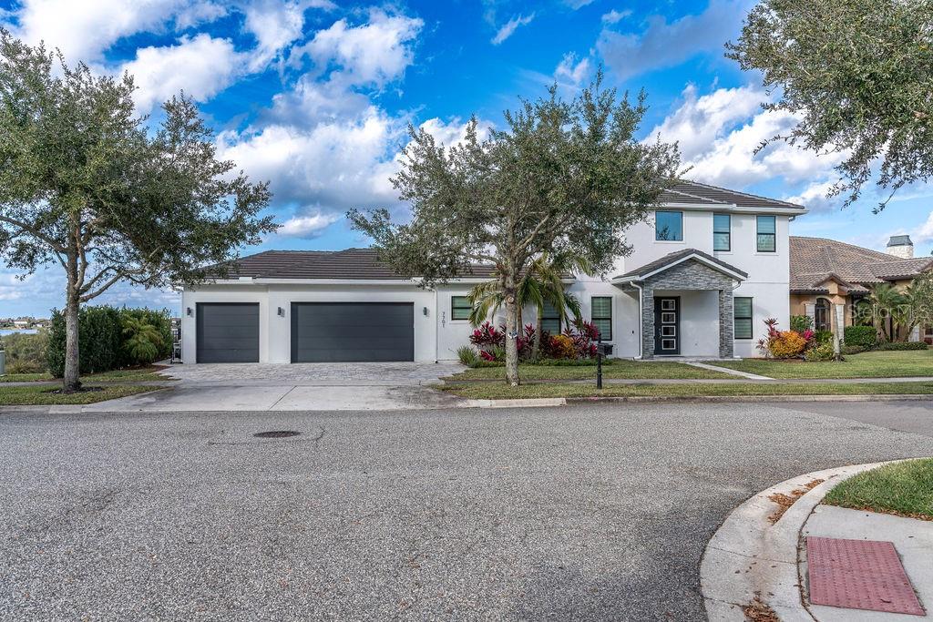 A two-story house with a three-car garage, white stucco exterior, and a paved driveway — 7701 SUMMERLAKE POINTE BOULEVARD, WINTER GARDEN, FL
