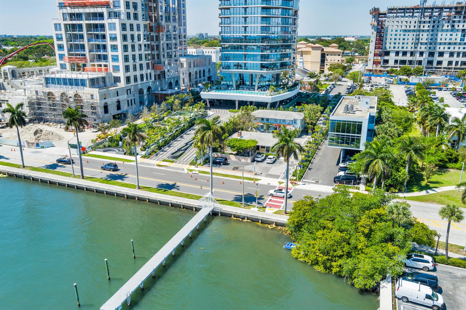 An aerial view shows a waterfront property with a dock, palm trees, and nearby high-rise buildings — 1301 S Flagler Drive, West Palm Beach FL 33401, WEST PALM BEACH, FL