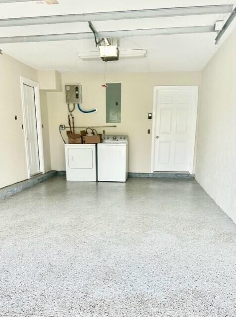A garage with a speckled epoxy floor, a washer and dryer, and two white doors — 3021 Florida Boulevard, Delray Beach FL 33483, DELRAY BEACH, FL