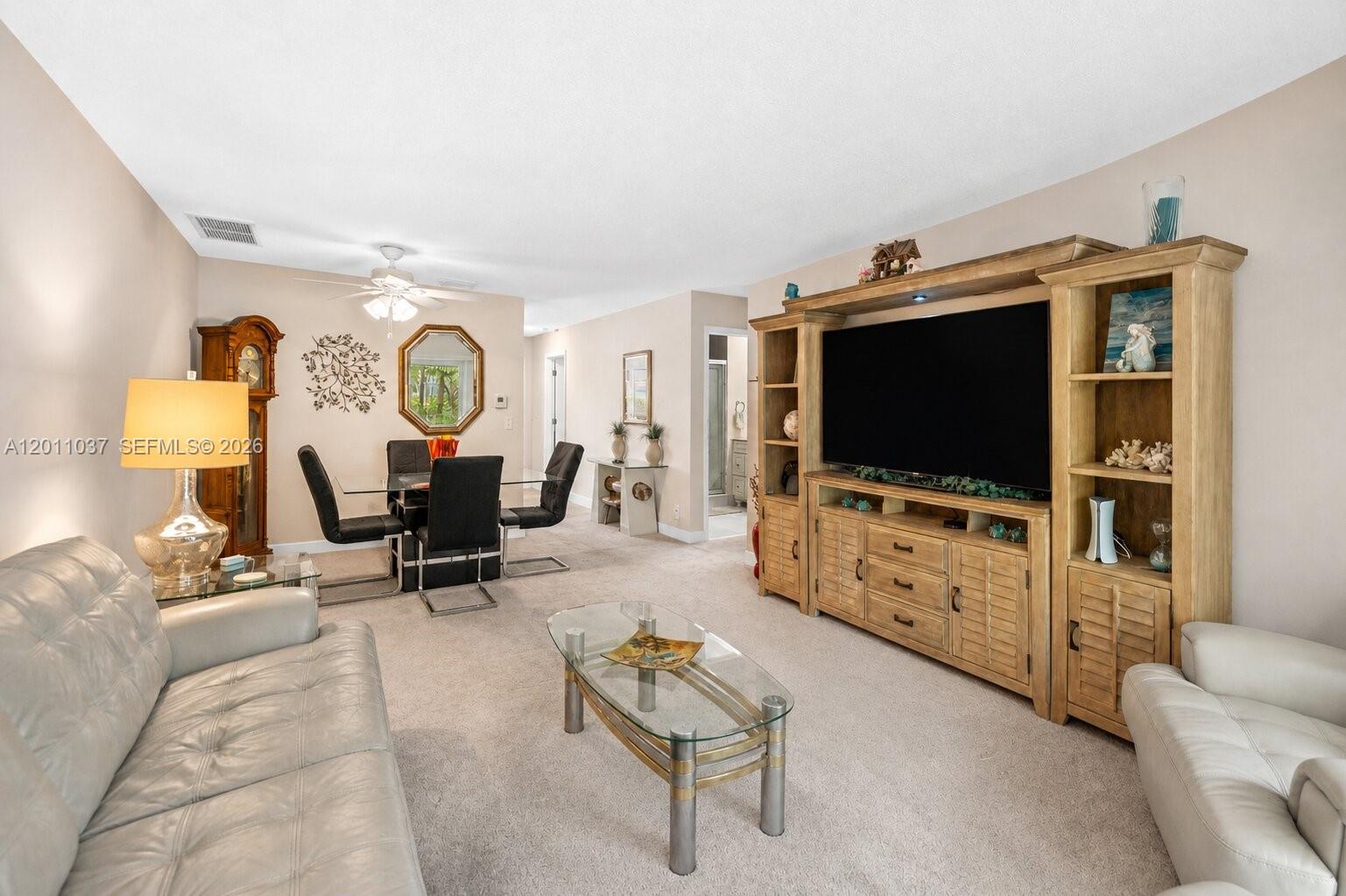A living room features a large entertainment center, a glass coffee table, and dining area — 8887 Bella Vista Dr # 8887, Boca Raton FL 33433, BOCA RATON, FL