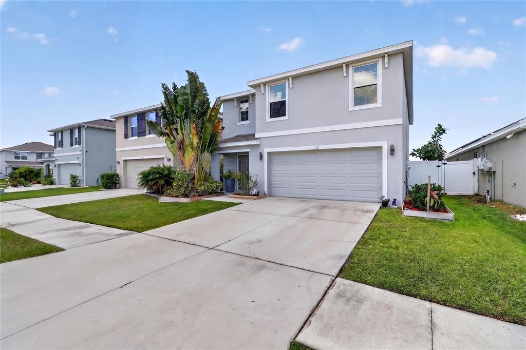 A two-story gray suburban house with a two-car garage and a concrete driveway — 440 OLIVE CONCH STREET, RUSKIN, FL