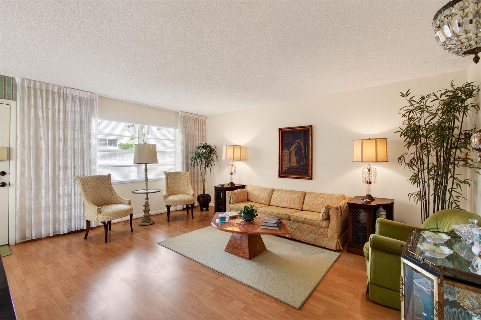 A living room features a patterned sofa, two armchairs, a coffee table, and wood flooring — 349 Capri # H, Delray Beach FL 33484, DELRAY BEACH, FL