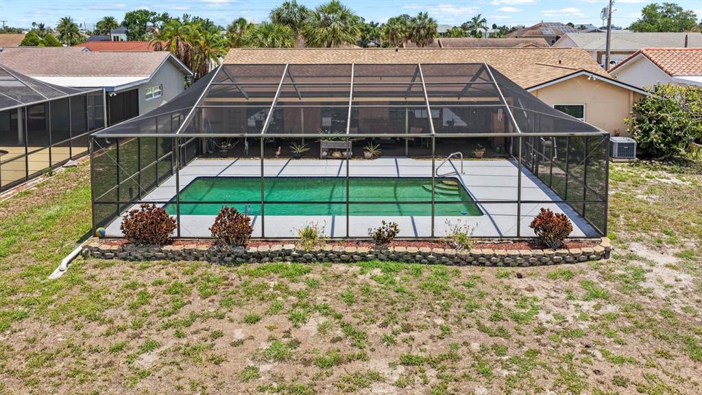 An aerial view of a backyard swimming pool enclosed by a screened lanai — 736 FLAMINGO DRIVE, APOLLO BEACH, FL