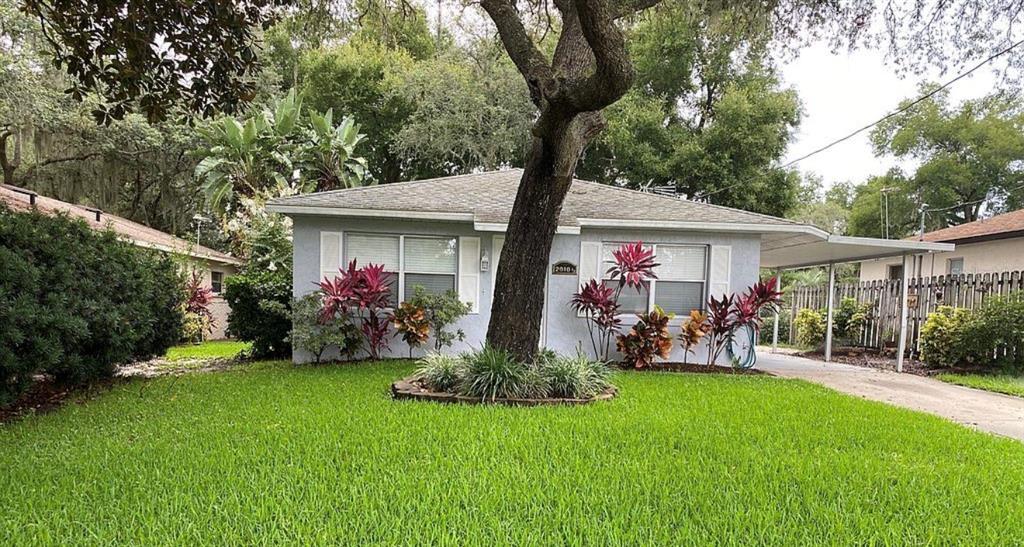 A single-story house with a gray exterior, a front lawn, and a carport — 2010 1/2 VINE STREET, LEESBURG, FL