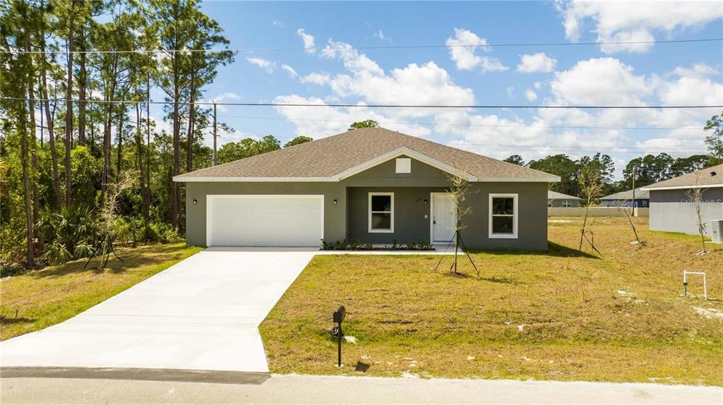 A single-story house with a gray exterior, white garage door, and a concrete driveway — 971 WELLINGTON STREET SW, PALM BAY, FL