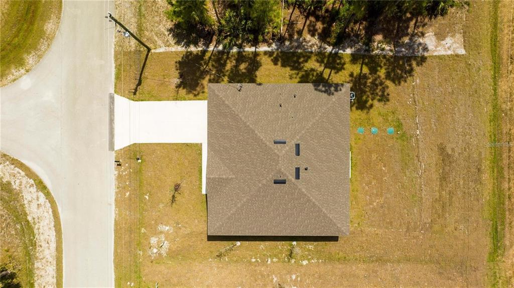 An aerial view shows a house with a shingled roof, driveway, and surrounding grassy yard — 971 WELLINGTON STREET SW, PALM BAY, FL