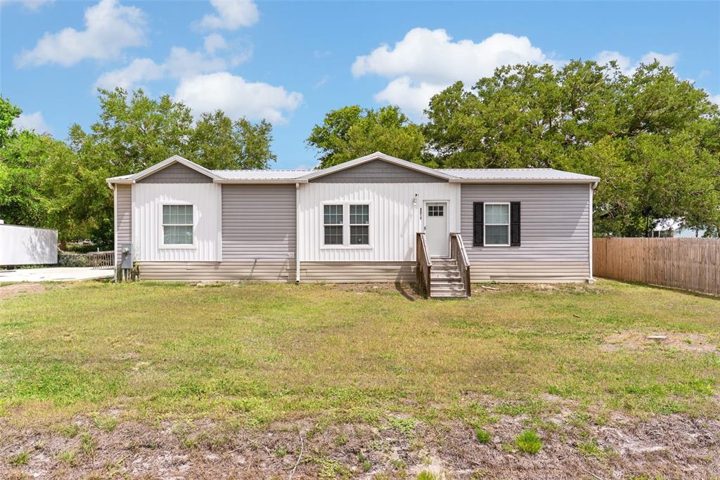A single-story manufactured home with grey and white siding sits on a grassy lot — 8010 PALMER ROAD, BARTOW, FL