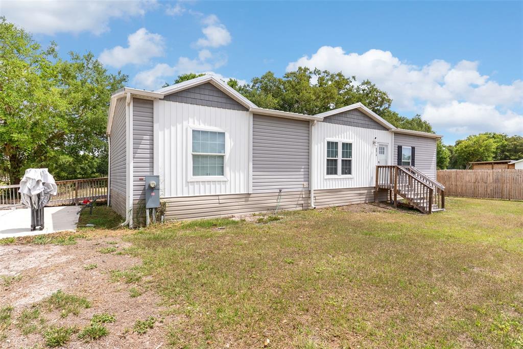 A single-story manufactured home with grey and white siding sits on a grassy lot — 8010 PALMER ROAD, BARTOW, FL