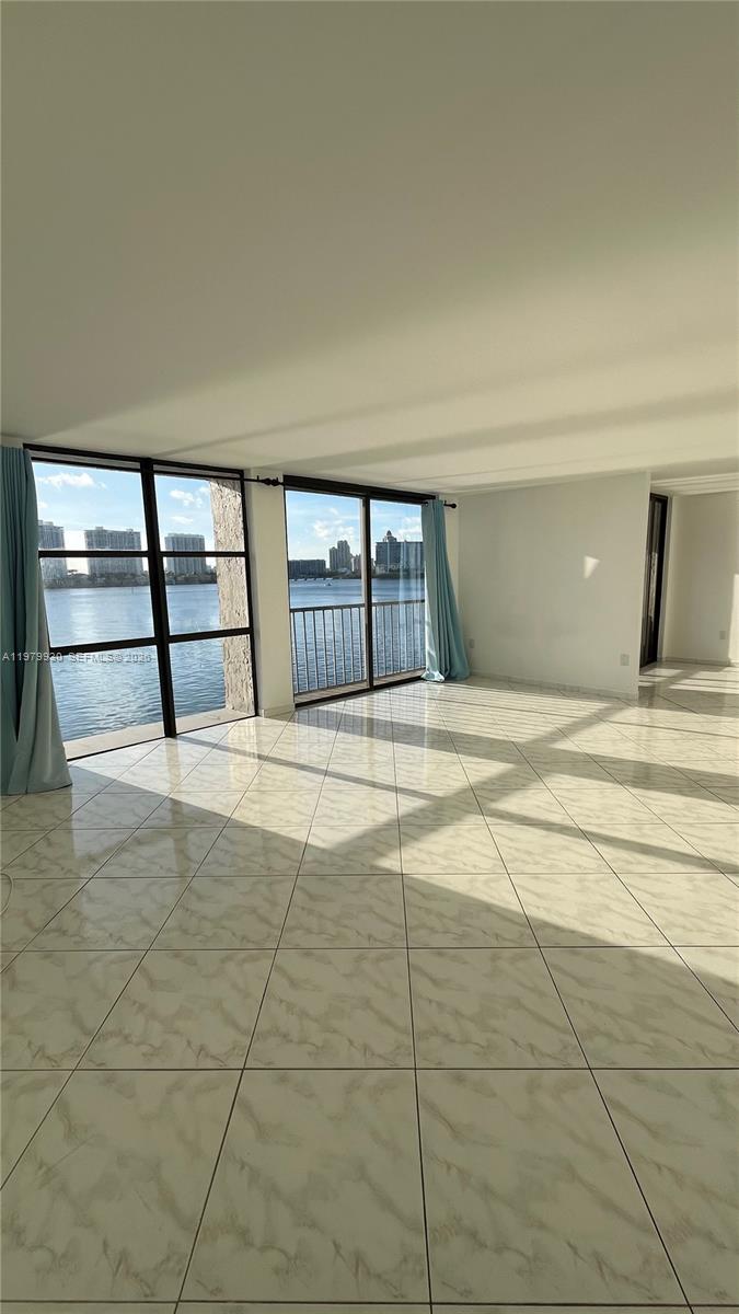 A bright living room with white marble-style tile floors and floor-to-ceiling windows overlooking water — 17500 N Bay Rd # S403, Sunny Isles Beach FL 33160, SUNNY ISLES BEACH, FL