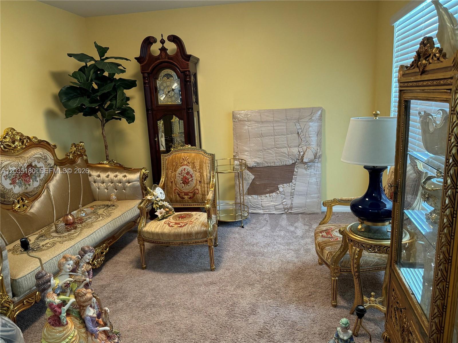 A living room features ornate gold-trimmed furniture, a grandfather clock, and a large wrapped painting — 8171 Gopher Tortoise Trl, Lehigh Acres FL 33972, LEHIGH ACRES, FL