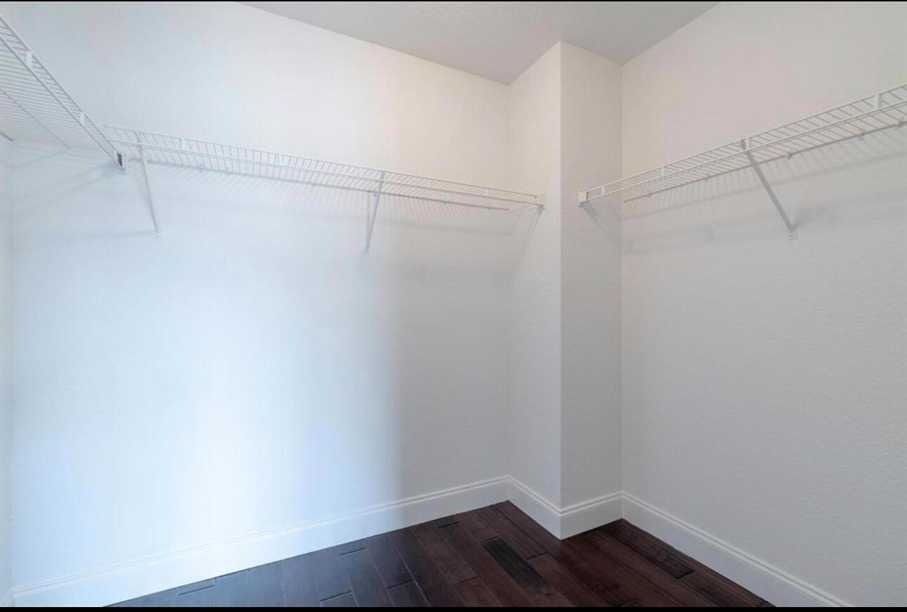 A walk-in closet features white wire shelving, white walls, and dark wood flooring — 4147 Meade Way, West Palm Beach FL 33409, WEST PALM BEACH, FL