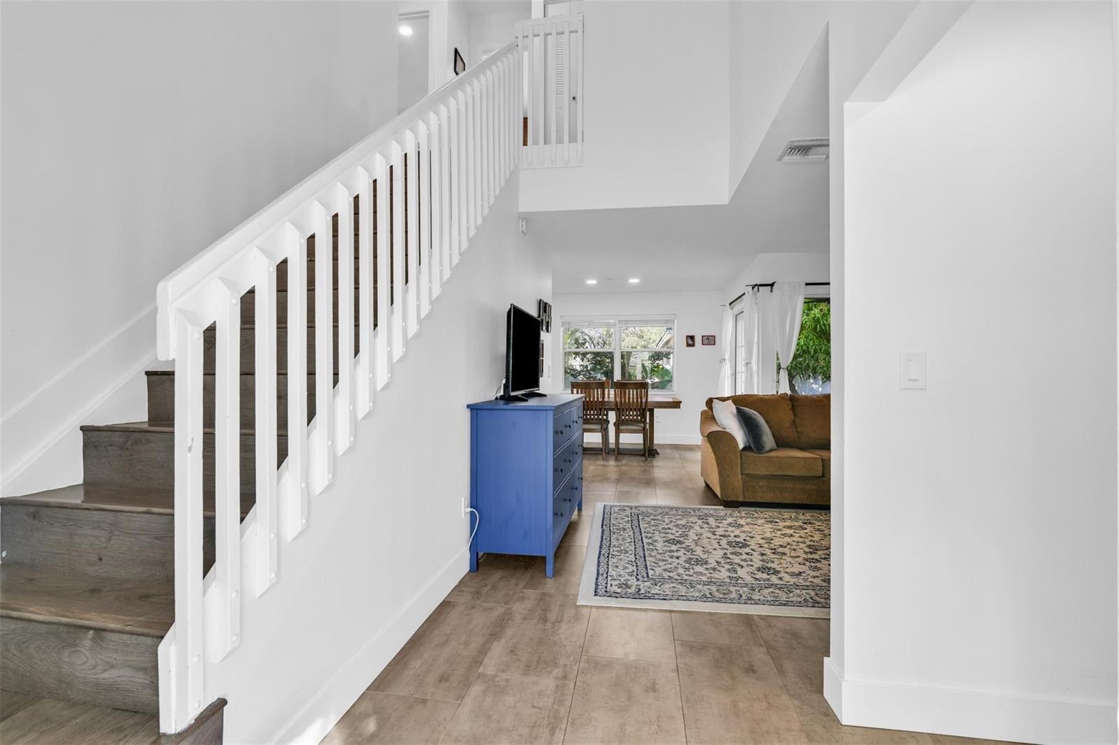 A view from a hallway toward a living room and dining area with stairs — 843 NW 98th Avenue, Plantation FL 33324, PLANTATION, FL