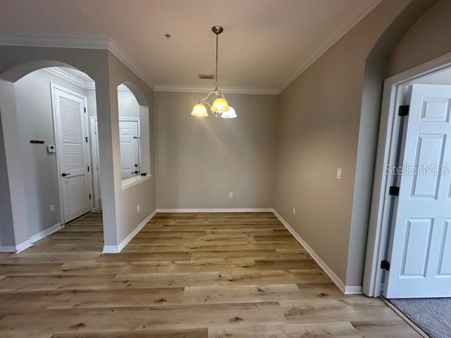 A dining area features light wood-look flooring, beige walls, and a three-light pendant fixture — 11565 MIZZON DRIVE UNIT 308, WINDERMERE, FL