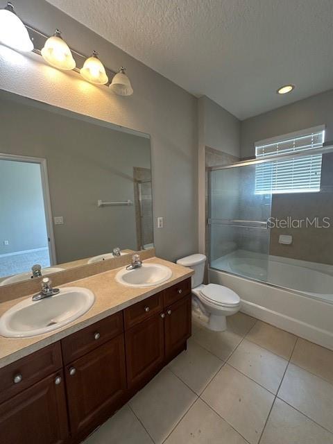 A bathroom features a double vanity with wood cabinets, a large mirror, and a shower-tub combo — 11565 MIZZON DRIVE UNIT 308, WINDERMERE, FL