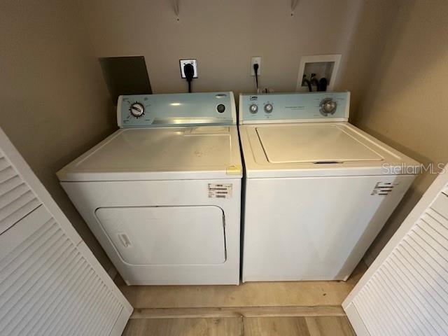 A laundry closet contains a white top-load washing machine and a matching electric dryer — 11565 MIZZON DRIVE UNIT 308, WINDERMERE, FL