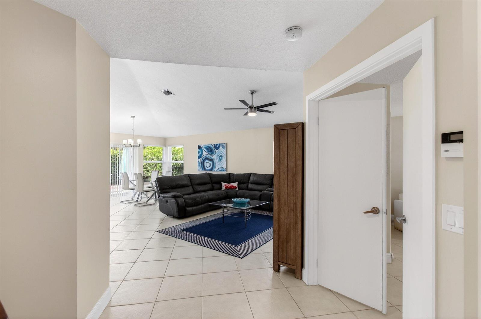 A view from a hallway looking into a living room with tile floors and furniture — 2034 NW 52nd Street, Boca Raton FL 33496, BOCA RATON, FL