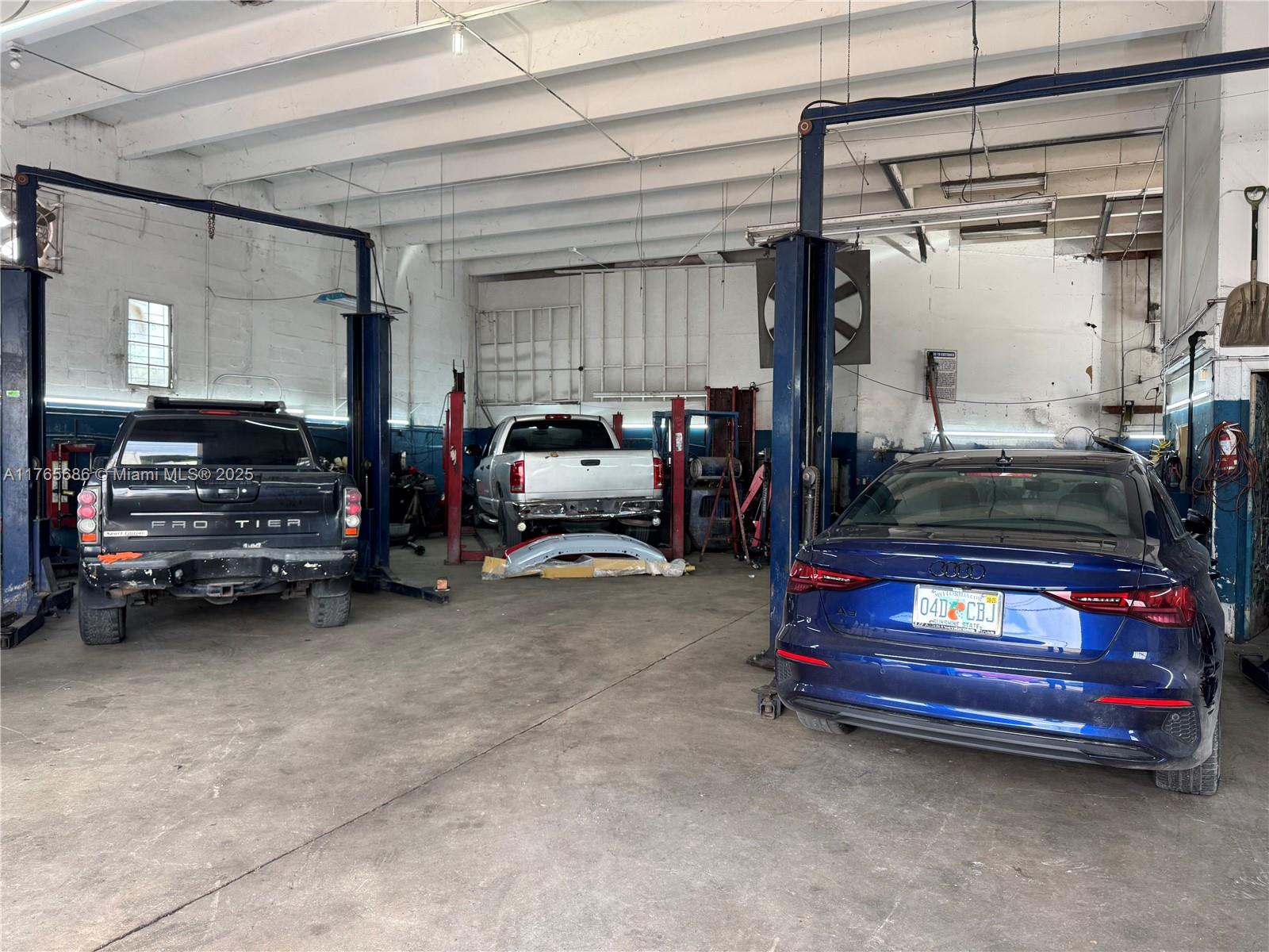 An auto repair shop features three vehicles parked inside a large warehouse space with lifts — 2620 SW Ali Baba Ave, Opa-Locka FL 33054, OPA-LOCKA, FL