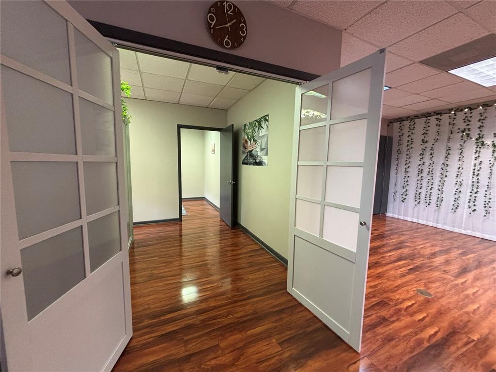 A view through double glass-paneled doors into an office space with wood-look flooring — 1750 W BROADWAY STREET UNIT 112, OVIEDO, FL
