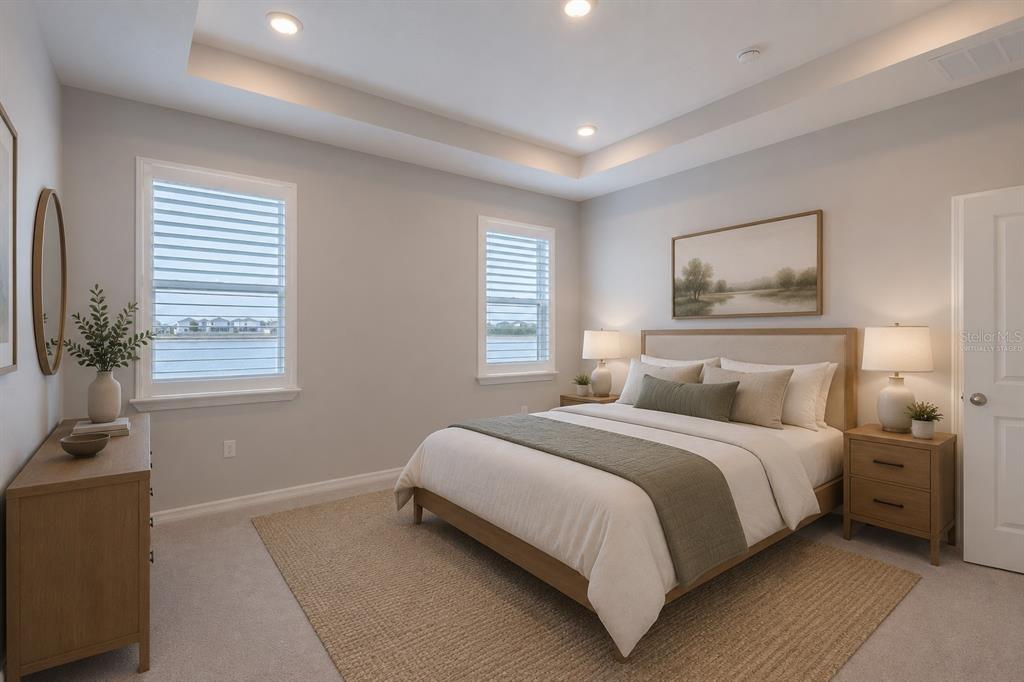 A bedroom with a tray ceiling, two windows, and a bed with neutral bedding — 1215 OCEAN SPRAY DRIVE, RUSKIN, FL