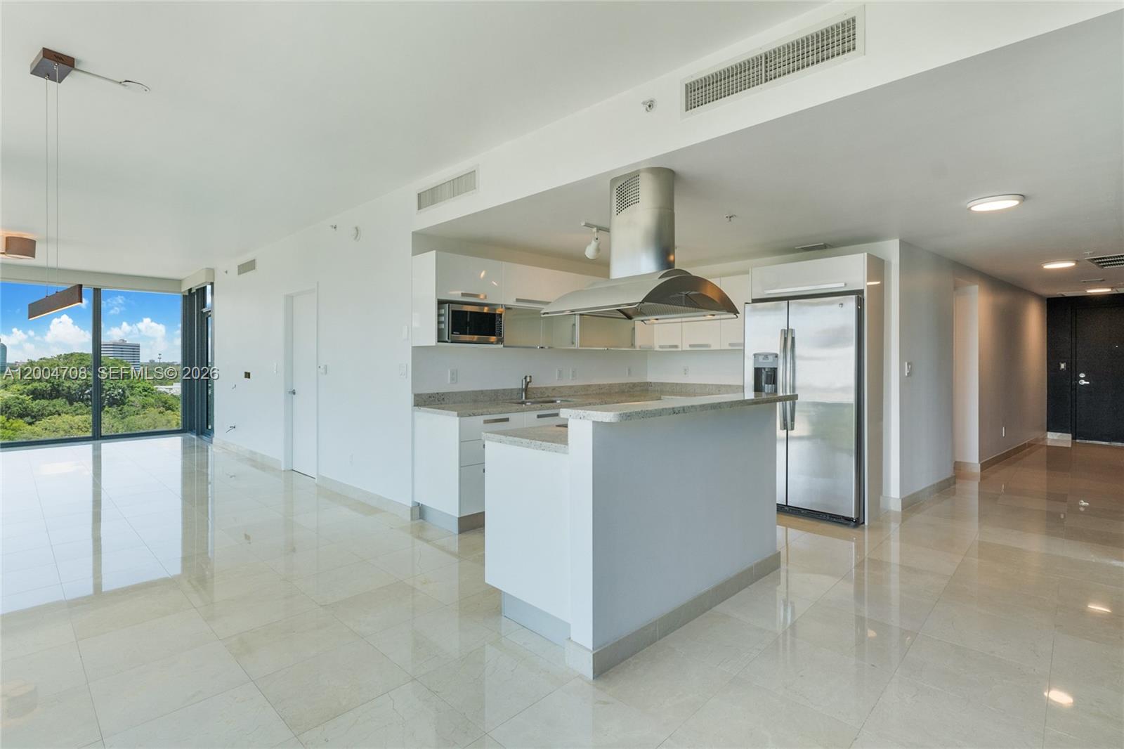 A modern kitchen features white cabinets, stainless steel appliances, and a peninsula island — 601 NE 36th St # 801, Miami FL 33137, MIAMI, FL