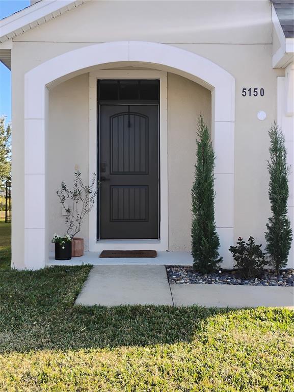 The exterior entrance features a dark door under a white arched entryway with two topiaries — 5150 SAN PALERMO DRIVE, BRADENTON, FL