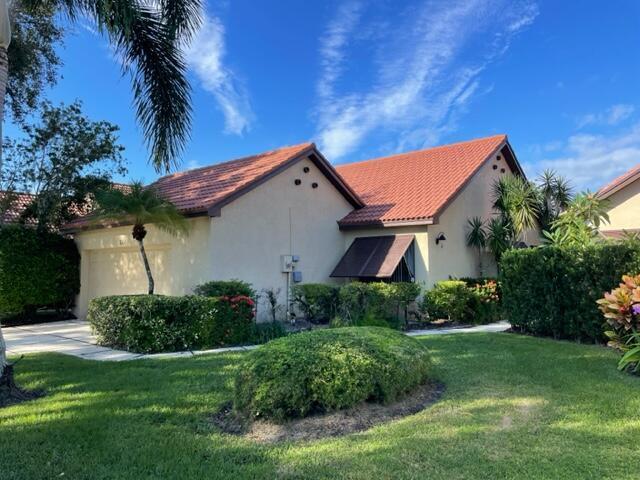 A single-story house with a red tile roof, beige stucco walls, and a manicured lawn — 36 Ironwood Way N # 36, Palm Beach Gardens FL 33418, PALM BEACH GARDENS, FL