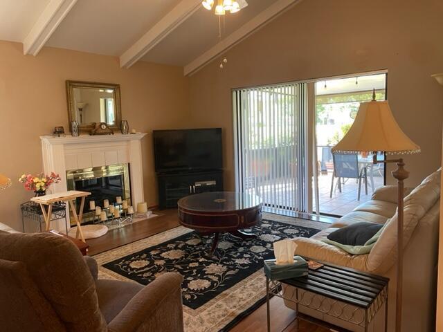 A living room features a fireplace, television, area rug, and sliding glass doors to a patio — 36 Ironwood Way N # 36, Palm Beach Gardens FL 33418, PALM BEACH GARDENS, FL