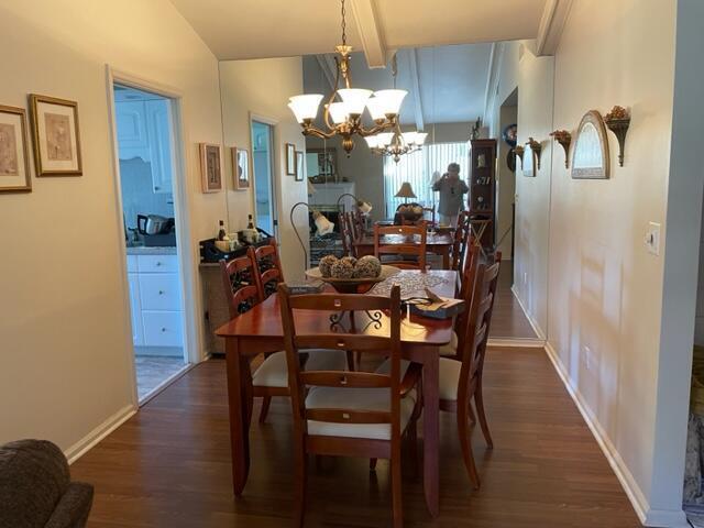 A dining room features a wooden table, chairs, a chandelier, and a mirrored wall — 36 Ironwood Way N # 36, Palm Beach Gardens FL 33418, PALM BEACH GARDENS, FL