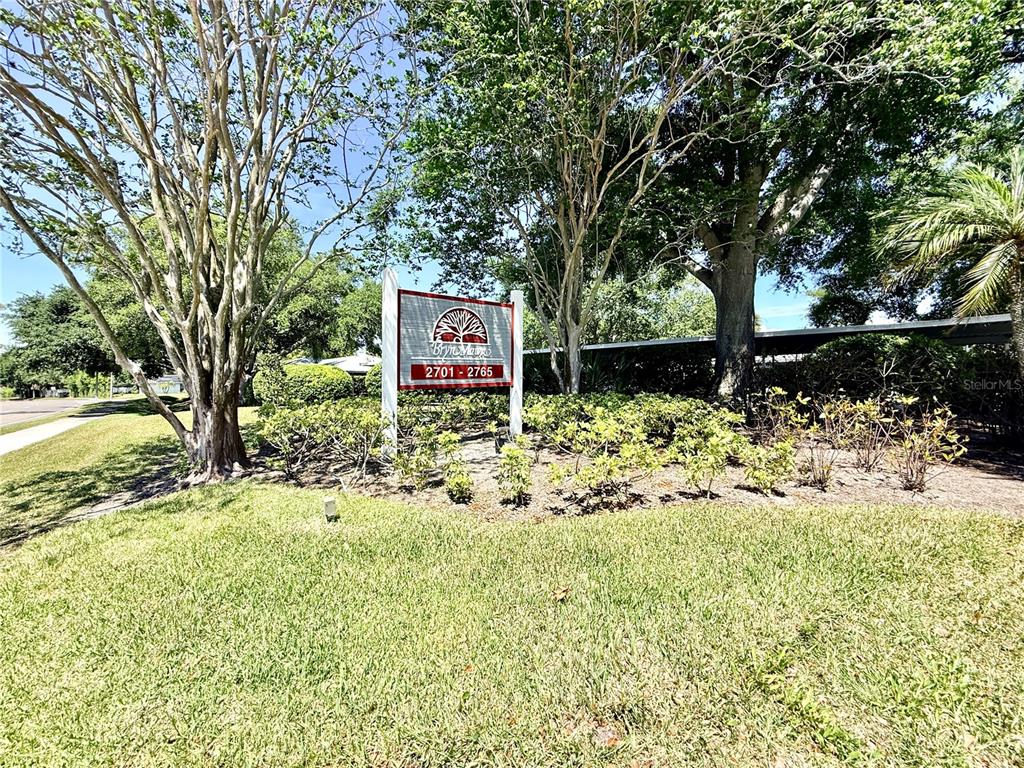 A sign for Bryn Mawr stands in a grassy area surrounded by trees and shrubs — 2749 COUNTRYSIDE BOULEVARD UNIT 14, CLEARWATER, FL