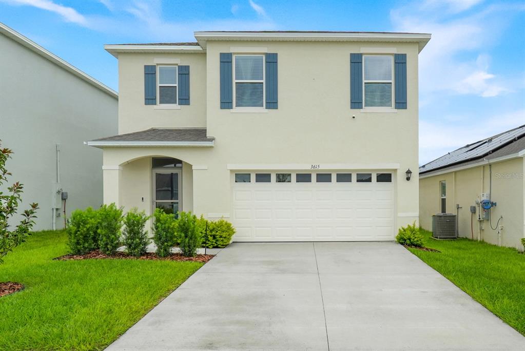 A two-story house with a beige exterior, blue shutters, and a two-car garage — 3615 SALVIA COURT, TAVARES, FL
