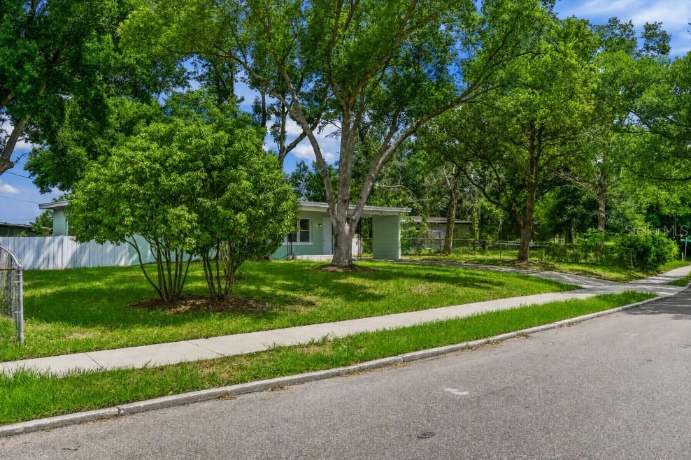 A light green house exterior features a front porch, a carport, and two white doors — 1435 EDEN DRIVE, APOPKA, FL