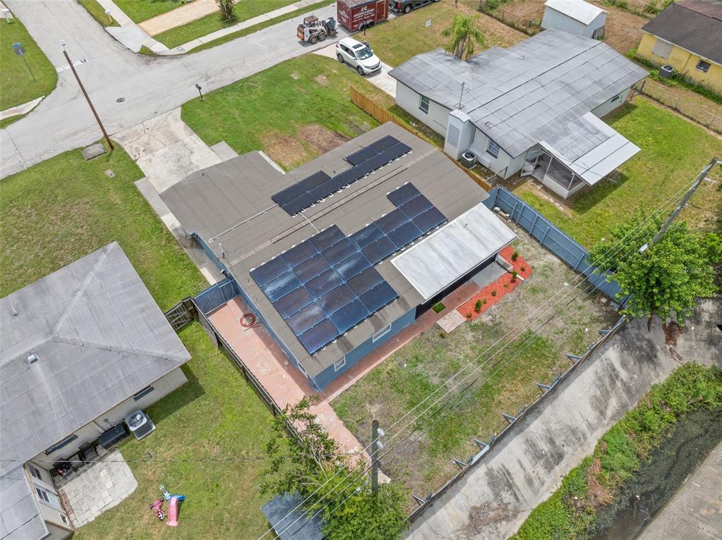 An aerial view shows a house with a flat roof featuring multiple solar panel arrays — 9780 53RD STREET N, PINELLAS PARK, FL