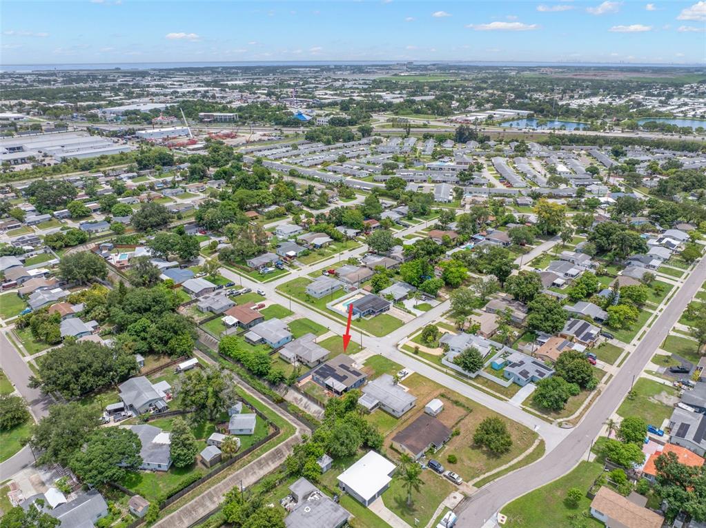 An aerial view shows a residential neighborhood with a red arrow pointing to a house — 9780 53RD STREET N, PINELLAS PARK, FL
