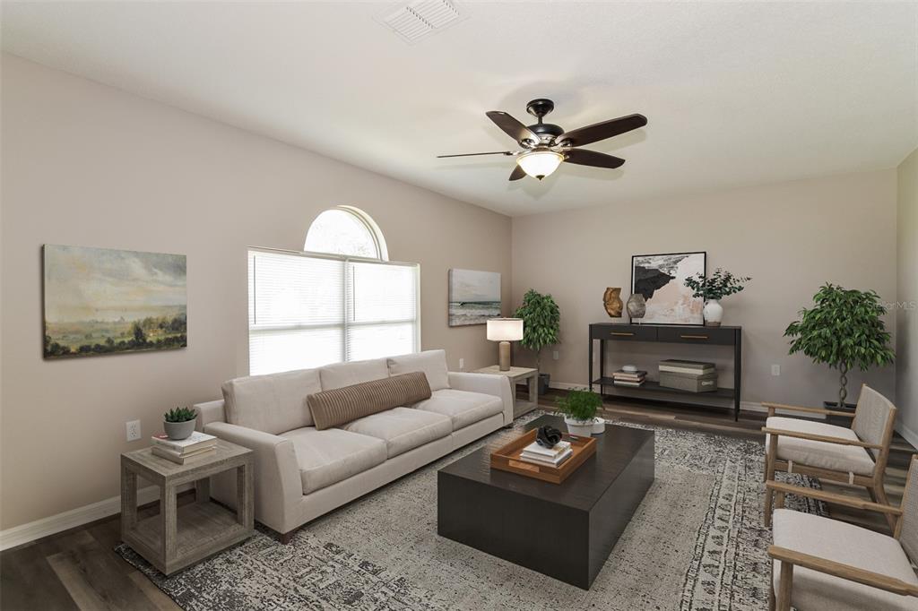 A living room with a beige sofa, dark coffee table, two armchairs, and a ceiling fan — 16249 WILKINSON DRIVE, CLERMONT, FL