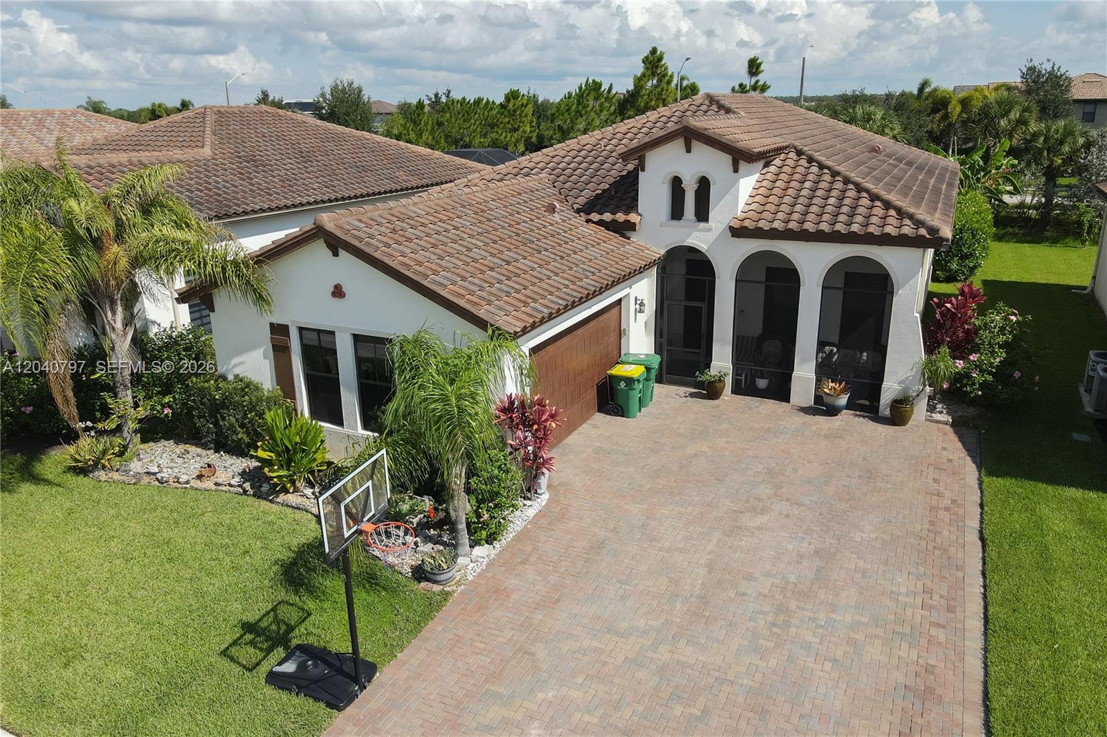 An aerial view shows a single-story house with a tile roof, paved driveway, and basketball hoop — 4742 Corrado Ave, Ave Maria FL 34142, AVE MARIA, FL