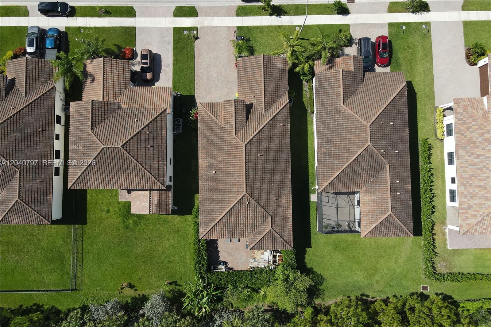 An aerial view shows three suburban houses with tiled roofs and driveways — 4742 Corrado Ave, Ave Maria FL 34142, AVE MARIA, FL