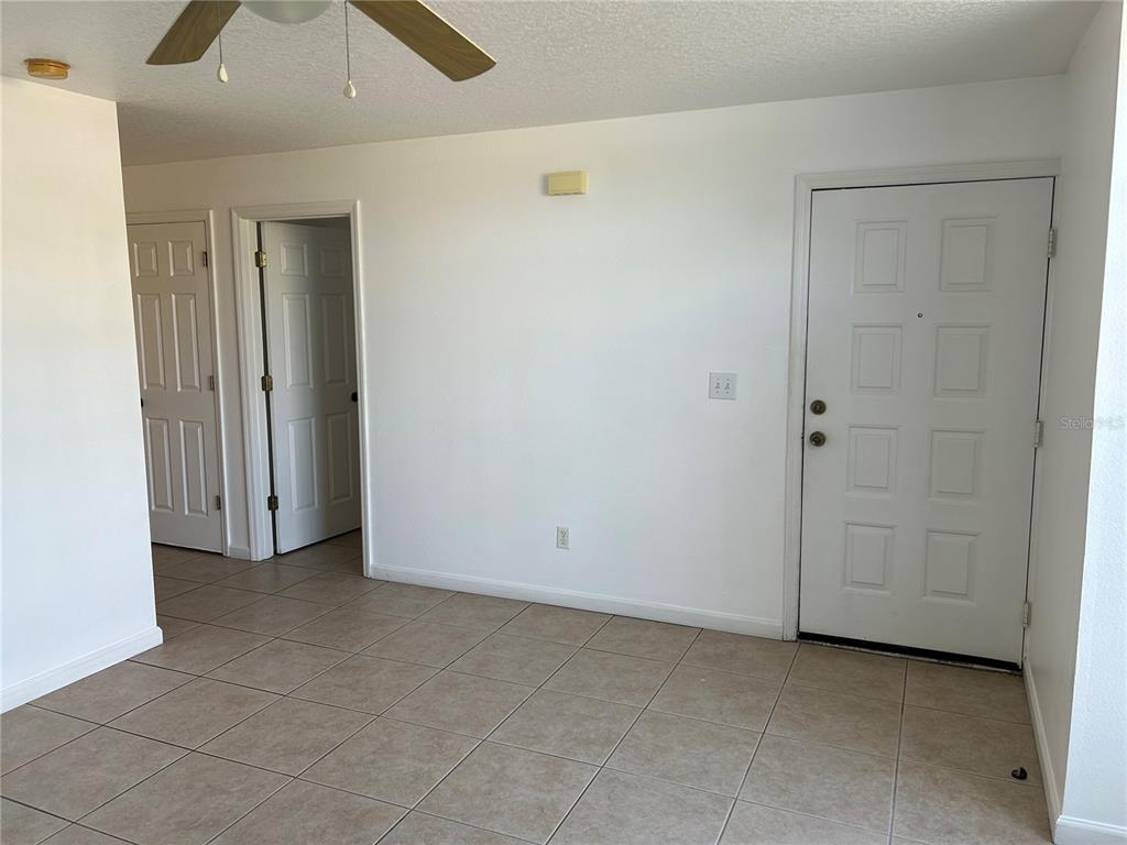 An interior view shows a tiled room with two doorways and an exterior door — 3072 SHINGLE CREEK COURT, KISSIMMEE, FL