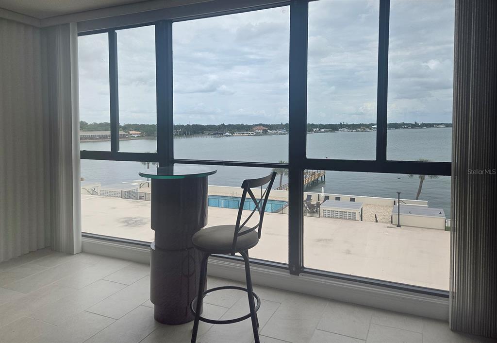 A high-top table and chair sit in front of a large window overlooking a bay — 7100 SUNSHINE SKYWAY LANE S UNIT 503, ST PETERSBURG, FL
