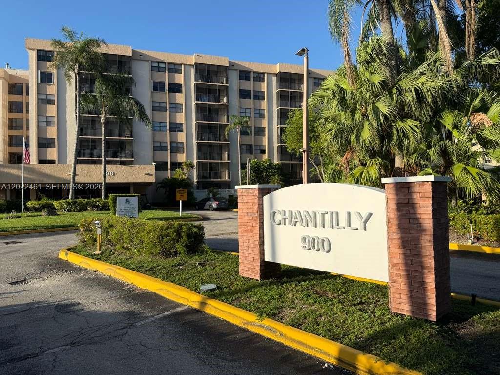 A multi-story apartment building stands behind a brick sign labeled Chantilly 900 — 900 NE 195th St # 618, Miami FL 33179, MIAMI, FL