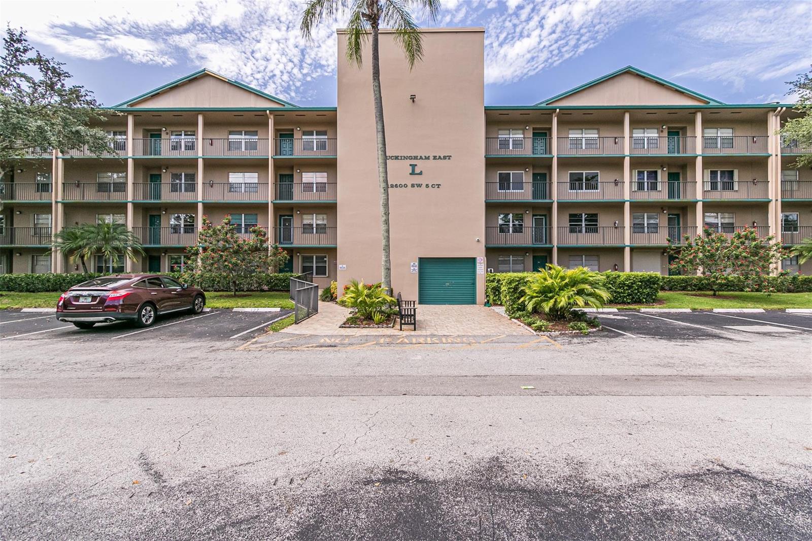 A multi-story apartment building with a central tower, balconies, and a parking lot in front — 12600 SW 5th Court # 408l, Pembroke Pines FL 33027, PEMBROKE PINES, FL